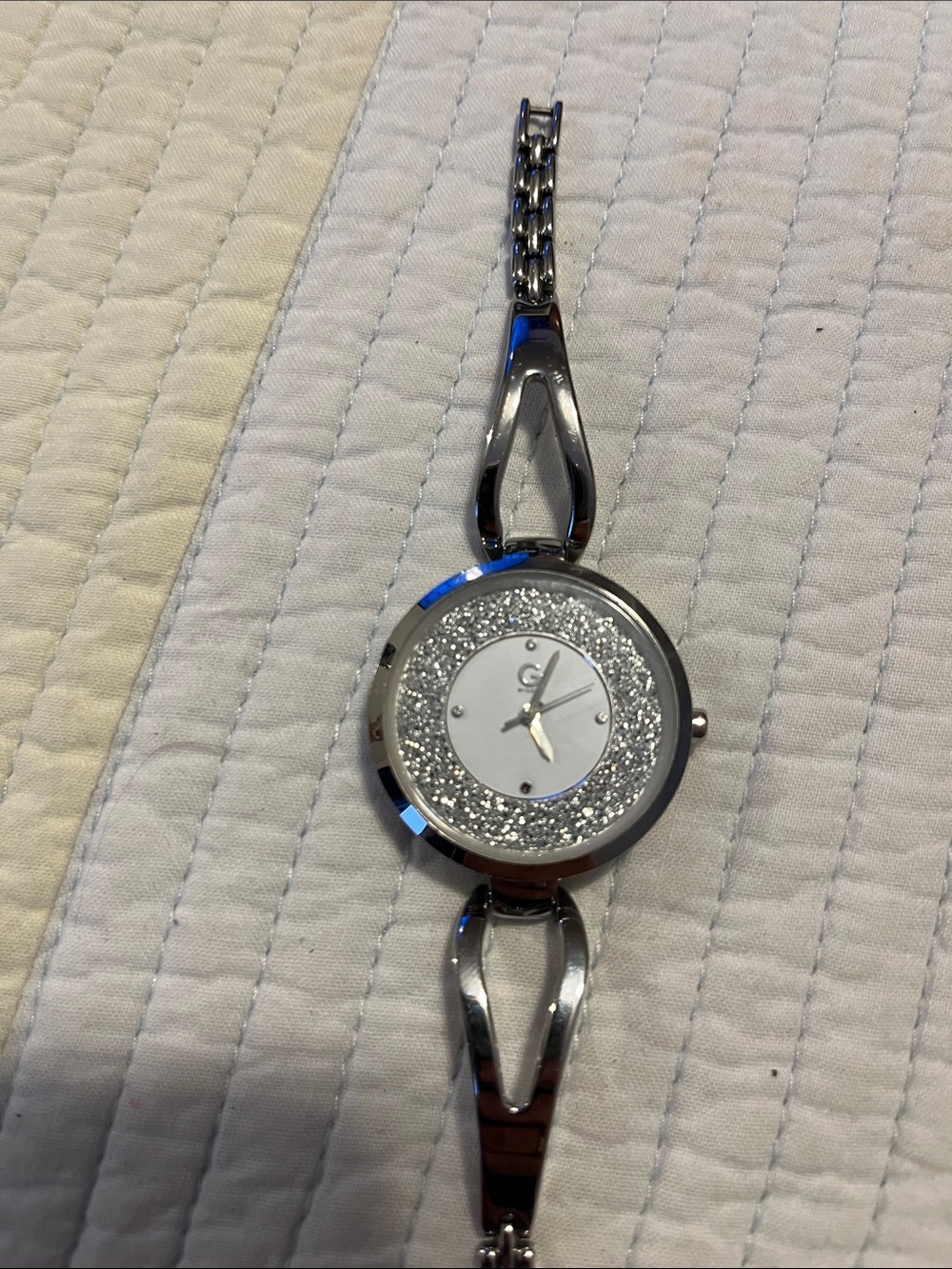 Style: Silver-tone stainless steel with a crystal bezel and sparkle dial.